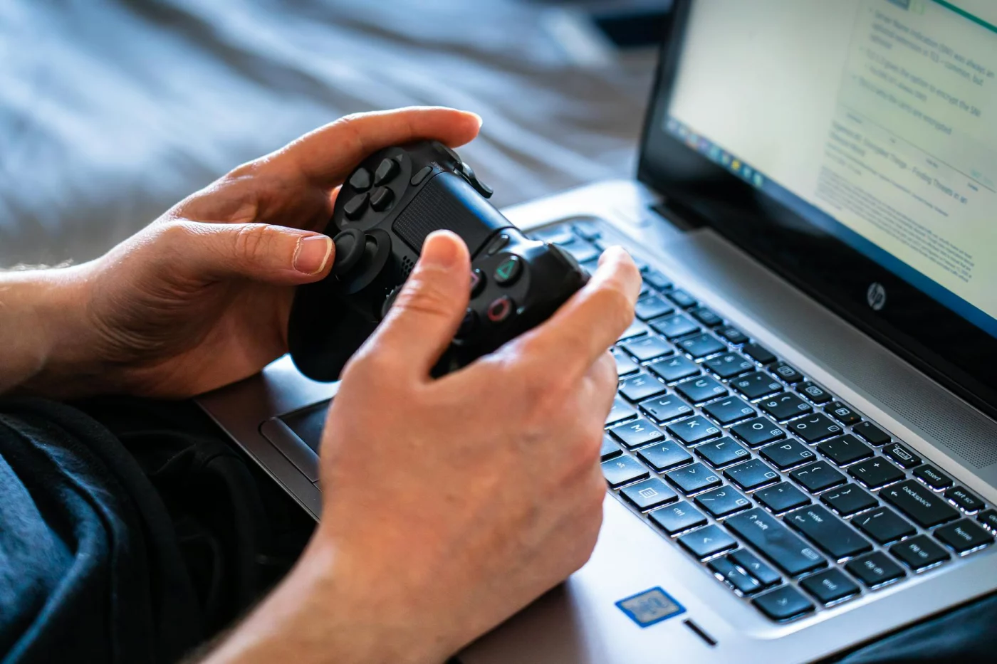 Player using a controller and laptop while researching a Marvel Rivals ban appeal in a gaming FAQ guide